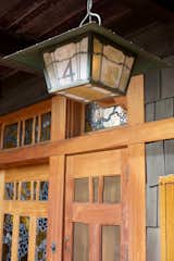 The home is surrounded by open porches that are constructed of cedar. The house’s art glass—shown here on the front door—acted as a way to bring light into the space before there was electricity.&nbsp;