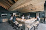 At KazuNori’s new second location, Marmol Radziner built the U-shaped bar out of bleached eucalyptus wood, while the walls are made of plaster and board-and-batten wood. The sculptural dropped ceiling is constructed of bleached rustic white oak and lined with warm lighting.