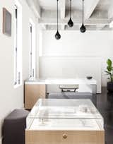 Above Lee’s custom desk hangs three matte black Drop Light Pendants that were designed by Early Work.&nbsp;