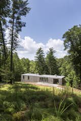 The simple bar-shaped house is buried into the hillside, which allows for unobstructed views of the woods below. #dwelllpow