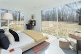 The bedrooms enjoy views of the wooded surroundings through large expanses of glass.&nbsp;