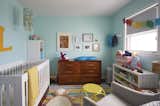Kids, Neutral, Bedroom, Rug, Rockers, Storage, Bookcase, Toddler, Dresser, and Dark Hardwood Like they thought may be in their future, they now share this home with their two-year-old daughter, whose room shares the upper floor with the master bedroom and the office.  Kids Bedroom Neutral Dresser Rockers Dark Hardwood Photos from Clever Storage Solutions and a Shifted Layout Revive This 1950s Chicago Home