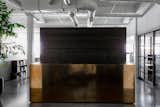 Hollis points out, “You move from a dark reception salon into a bright white open space. The contrast of moving from darkness into light is always part of my work.” The reception desk is a brass-clad box custom made by Chris French Metals—Hollis’ ode to Donald Judd.
