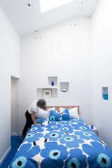 The cut-outs were added into the bedroom walls while the bed is outfitted with one of Marimekko's classic duvet covers.