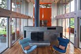 Corrugated-steel room divider / hearth with a fireplace inside.

 #interstice #intersticearchitects #hearth #roomdivider  #bradlaughton #bradlaughtonphotography #orange #bright #color #kitchen #livingroom #diningroom #cabinetry  #highceilings #beachhouses #beachhouse  #britishcolumbia #vancouverisland #smokestack