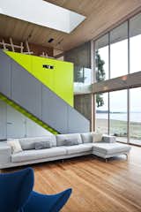 A sleek  staircase leads from the living room to a study. The bright green accent wall includes storage for a projector and book case. 

#green #limegreen #bright #color #livingroom #entertainmentroom #staircase #storage #beachhouse #beachouses #interstice #intersticearchitects #bradlaughton #bradlaughtonphotography #britishcolumbia #vancouverisland