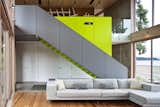 A sleek  staircase leads from the living room to a study. The bright green accent wall includes storage for a projector and book case. 

#green #limegreen #bright #color #livingroom #entertainmentroom #staircase #storage #beachhouse #beachouses #interstice #intersticearchitects #bradlaughton #bradlaughtonphotography #britishcolumbia #vancouverisland