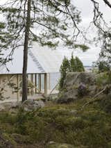 Exterior, House Building Type, and Wood Siding Material On Viggsö, an island of the Swedish Archipelago, architecture firm Arrhov Frick designed a two-story retreat, using simple but hardy materials. The roof, made from corrugated metal and fiber-reinforced plastic, joins the pine timber frame.  Photo 11 of 16 in Tile & Materials by Christine Ostler Palmer from A Swedish Summer Cabin That Sits  Above and Among the Trees