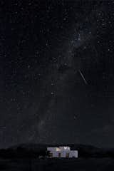 A view of the home by night, beneath the clear and starry desert sky.