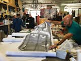 An artisan shows the life-size drawing that Gaetano Pesce created for an in-progress cabinet design. 