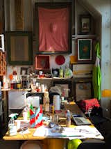 Decade's worth of work, including a pink resin portrait and his famous handmade exhibition invitations, hang over the desk of Gaetano Pesce in his studio in Brooklyn's Navy Yard.  Photo 4 of 28 in Inside the Workspaces of Creatives by Aileen Kwun