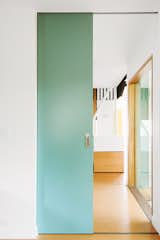 Sea green details appear throughout the house, peeking out from behind the exterior screen or on interior partitions.