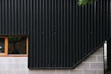 New black metal cladding joins cinderblock and wood-trimmed windows, two features more in line with the home's vintage.
