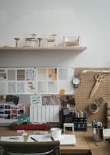 A shelf of models sits over a design station.