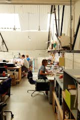 The design team works in the mezzanine, which is reached by a spiral staircase. Here they make models, finish in-house products, and work on prototypes.