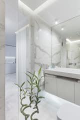 In the bathroom, marble walls provides a sleek backdrop.  Photo 3 of 6 in A Bright Palette Makes This Bulgarian Apartment Feel Bigger Than Its 600 Square Feet