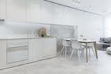 White appliances by Karim Rashid for Gorenje pair with concrete floors in the apartment's kitchen.