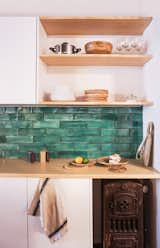 An original boiler the designers discovered during the renovation was kept in the kitchen as decoration. The counter is white pine, and the green tiles were sourced from Can Benito a studio in Mallorca.