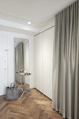 By the entrance, a silver curtains in KnollTextiles fabric hide a Poliform storage system and a Murphy bed.&nbsp;