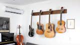 Composer and podcaster Hrishikesh Hirway hangs guitars and a bass from wall-mounts in his Echo Park home to conserve space.