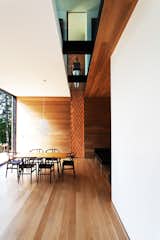 Dining Room, Chair, Table, Pendant Lighting, and Light Hardwood Floor A textured wood walls meets a glass cutaway on the second floor. The Wishbone chairs are by Hans Wegner.  Photo 2 of 5 in Is it Any Surprise a Sculptor Had a Hand in This Home?