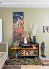 A living room vignette includes a 1950s batik Boy’s Day banner from Japan, Czech pottery, and a framed costume presentation from the estate of late opera diva Beverly Sills.