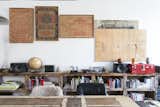 Office, Desk, and Study Room Type New York designer/artist Huy Bui decorated his home with a mishmash of curios, from 19th-century burlap sacks found at an antique fair to a plywood workbench he carved with a Festool plunge saw. The 17-foot-long shelving is made of old heart pine fashioned from the beams of brownstone renovation in the West Village.  Photos from Huy Bui’s Brooklyn Loft Is Like a
Self-Contained Jungle