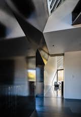 Contrasting materials, like blackened steel, silvery zinc, and white sheetrock, converge at odd angles.