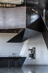 The glossy black and speckled gray counters of the kitchen mirror the rest of the home's incorporation of concrete and steel.