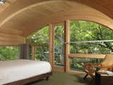 Casey Key HouseIn this playful treehouse-style bedroom, custom arched windows surround the room and meet the wooden ceiling. Elements of wood and modern architecture draw the sound of rustling leaves and midday breeze into this cozy treetop retreat.Architect: Jerry Sparkman; &nbsp;Architecture Firm: Sweet Sparkman Architects