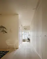Apartment in Kitasando is a minimal interior located in Tokyo, Japan, designed by Minorpoet. The clients approached the architects to renovate an apartment that was originally built in the 1960s. The renewal of the space would not only change the overall layout, but conceal the kitchen through a series of folding doors. The designer created a floor plan in which a narrow hallway would surround the living and dining area, which was meant to resemble a Kyoto townhouse.