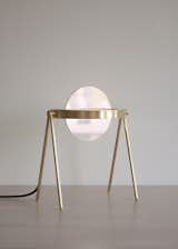 Janus is a minimal table lamp created by Brooklyn-based designers Trueing. Janus, one of Saturn’s outermost rings, as well as the two-faced, coin-gracing Roman deity of transitions, is the eponym and inspiration for Trueing’s newest table lamp. With an adjustable shade of dichroic glass at its center, the lamp’s luminous brass ring shines inwards to create a colorful, aurora-like effect. Trueing designed the lamp in the spirit of planetary movement and deep space, focusing on their desire to create a transitional object that evolves with its environment. To achieve this experience, Trueing equipped the lamp with a shade of color-changing dichroic glass positioned at the center of a halo of dimmable LEDs. A small knob at its side allows the user to rotate the shade 360º, casting different colors of light as it rotates. When Janus is turned off, the dichroic qualities render the glass as mirrored, colored, or transparent depending on the ambient light.