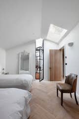 Bedroom, Wall Lighting, Light Hardwood Floor, Recessed Lighting, Night Stands, Bed, Table Lighting, and Chair  Photo 8 of 13 in A London Shed Becomes an Airy Home Lit By Three Courtyards from The Courtyard House