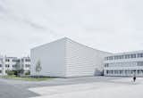 Silhouette Lens Lab is a minimalist architecture project located in Linz, Austria, designed by X Architects. The facility is a production and warehouse center characterized by an array of circular windows that pivot open horizontally. One side of the building’s facade features a wall of smaller circular openings that playfully interact light with shadow when viewed upon from the inside.