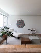 Apartamento na Mata is a minimal residence located in São Paulo, Brazil, designed by Meireles + Pavan. Apartamento na Mata is a 165m2 apartment situated in the bustling neighborhood of Itam. Taking a minimalistic approach, the challenge for the architects André and Brunno was to create a young and relaxed apartment that would reflect the very receptive attitude of the owners. For a couple that loves to interact with friends and family over cooking, the main solution was to integrate all the social spaces in the apartment: the social areas such as the hall, the living room and the dining, as well as the kitchen ended up form a unique and intimate area where everything is connected. It was created a more spacious and inviting space for the hosts. To reinforce the integration, the ripped lining runs up to the dinning table, becoming a unifying element in the room. The kitchen, on the other hand, communicates itself behind a long open balcony that can be closed by sliding doors. The furniture was chosen to give the apartment a more flexible and contemporary feeling. The woodwork was designed to be clean and functional. This minimalistic approach is present in all of the studio’s works: neutral colors, open spaces and as little decoration as possible. The usage of materials such as wood and concrete were chosen to appeal to the owner’s request on a more discreet and elegant design.