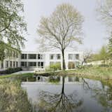 The Sun Garden is a minimal nursing home created by Germany-based designers Ecker Architekten. The focus of the architects initially lay on the modules of the residents’ rooms, which were designed according to the daily routine of the residents and the needs of the nursing staff. The rooms were created to be spacious and welcoming. This was important for the family-run foundation, not only as a comfort for the residents, but also to enable the nursing staff to work optimally. The light-filled interiors are developed entirely from the point of view of the residents: standing, sitting and lying down. The view into the park-like environment is always possible and offers through the floor-deep glazing bedridden residents a reference to the environment. Another focus of the design is on the common areas. The corridors of the two residential floors are expanding into recreation areas as communicative centers. These are highlighted by acoustically effective wood paneling in oak on the wall and ceiling as a separate room layer. A finely tuned range of natural surfaces creates an atmosphere with a high quality of stay despite the high hygiene requirements.