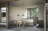 Doppelhaus Trausner is a minimalist home located in Schärding, Austria, designed by LP architektur. The project, which consists of two one-story structures – the smaller one for the parents, the larger one for the young, growing family, was sensitive to topography and vegetation, which formed a courtyard-like ensemble with the existing farm building. The exploitation of the natural topography on the property opens up the possibility of differentiated room heights and spatial spatial sequences. The interface between public and private was delineated at the property’s boundaries, and not at the respective house. Invisibly-protected outdoor areas or differentiated garden and landscape references complement the qualities of the considerate interaction of the buildings in the ensemble. The duality of the surrounding garden is also thematized and made tangible in the interior.