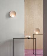Musa is a minimalist lamp designed by Stockholm-based studio Note Design Studio for Vibia. Musa is a lamp of organic qualities that attracts the eye due to its lighting function. A delicate and elegant design where a symbiotic interaction is established between the small hand blown opal glass-sphere and the dish that holds and reflects it. The distinctive composition of two circles, one of light and the other of support, marks its balanced formal expression and its functional performance as a lamp. The slightly textured concave aluminum base captures the light from the simple diffuser and amplifies it smoothly. It’s made in three color options: white, salmon and mink grey, that adds to the warm quality of the lamp.