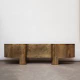 Custom Brass Desk is a minimalist desk created by Los Angeles-based designer Brian Thoreen. Thoreen creates furniture, architectural installations, and unique design objects that gather their ethos from the integral nature of the materials within the application. The drawers of the desk are constructed of walnut, contrasting nicely against the brass framework. On the surface of the desk, there are two cord organizers.