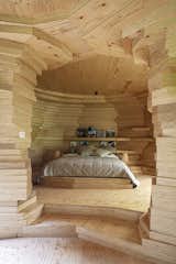 Bedroom, Ceiling Lighting, Medium Hardwood Floor, Bed, and Shelves  Photo 10 of 38 in This Beguiling Guesthouse in Belgium Has an Underground Cinema and a Watchtower from Alex' Guesthouse by Atelier Vens Vanbelle