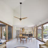 Blackbutt window treatments and a polished-concrete floor unify the kitchen, dining, and living areas on one end of the courtyard. A Haiku ceiling fan by Big Ass Fans provides extra air.&nbsp;