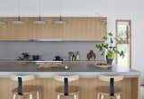 Caesarstone countertops are used in the kitchen. Skan pendants by Vibia hang above the island.