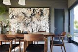 Interior design firm &amp; Daughters built the dining table, and the Hiroshima upholstered dining chairs are by Naoto Fukasawa from Mjölk. Harouna Ouedraogo artwork hangs on the wall.