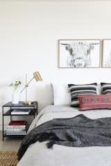 A Tim Gainey photograph of a Highland cow from Fine Art America sits above a red lumbar pillow by Amber Interiors and Restoration Hardware Bedding.&nbsp;
