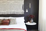 In the second bedroom, a macrame wall hanging and gold sconce were found at Etsy, which matches the sentiment of the DIY nightstand. Matteo bedding pops against the Midsummer Night wall color by Benjamin Moore.&nbsp;