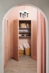 "The dramatically tall and wide arched entranceway with the modernized Louver closet doors reminds me of a 1930s Hollywood film set," Hesser says. The closets are used to store props for events and shoots, including lots of wine.&nbsp;