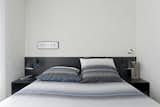 Bedroom, Bed, Night Stands, and Wall Lighting The black lacquer finish used in the common area was repeated in a headboard for the master bedroom.  Photos from A Brazilian Bachelor Pad Embraces Light and Darkness