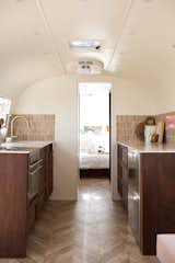 Kitchen, Marble, Ceramic Tile, Wood, Medium Hardwood, Refrigerator, Cooktops, Drop In, Wall Oven, and Recessed  Kitchen Wall Oven Drop In Recessed Wood Medium Hardwood Photos from This Chic Camper Will Make You Want to Be an Airstream Dweller
