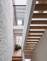 This minimalist staircase by architect Shane Neufeld is a beautiful blend of form and function. The townhouse in New York, New York, originally featured a stacked stair; however, this switchback design makes it feel bigger and brighter. The staircase is built from white oak treads and a painted steel handrail, allowing natural light to filter between the stairs offering more illumination to the dark area underneath.