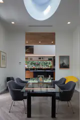 "Although the kitchen and dining room have distinct volumes, they are essentially connected to each other though the use of a full opening that shares the same ceiling height," he notes.